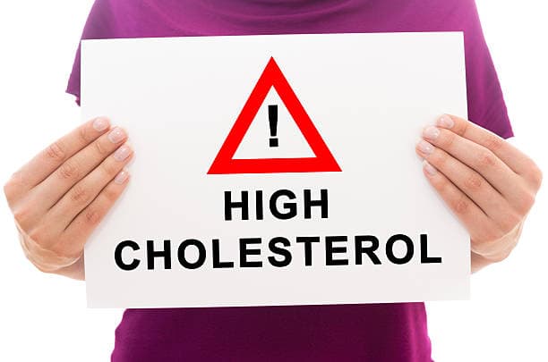 Girl holding white paper sheet with text High cholesterol