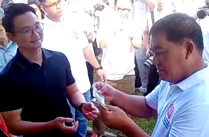 Gubernur Sulawesi Utara, Yulius Selvanus, memperhatikan STNK milik seorang warga yang datang mengurus pajak, Jumat 8 Agustus 2025.(meimo)