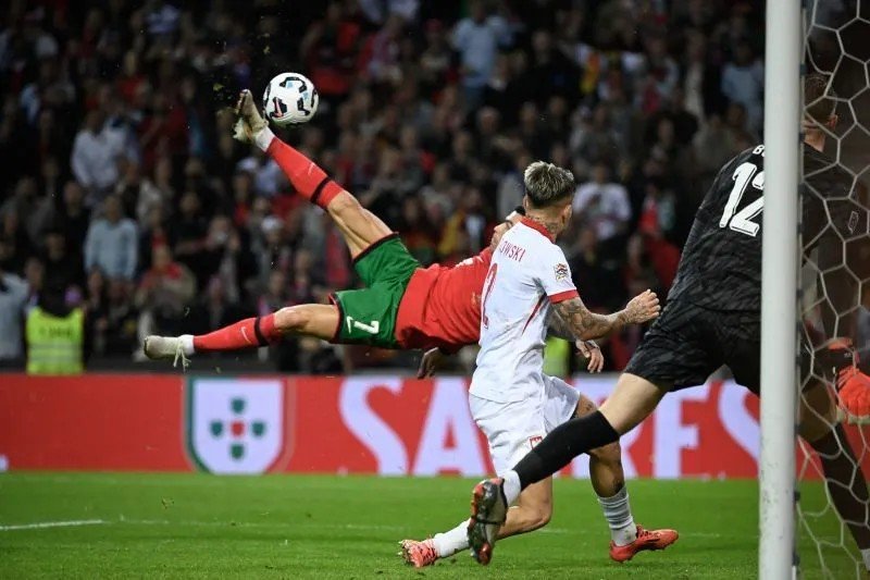 Penyerang Portugal Cristiano Ronaldo (kiri) mencetak gol kelima saat pertandingan Grup A Nations League kontra Polandia di Dragao stadium, Porto, Jumat (15/11/2024). (Photo by Miguel RIOPA / AFP) (AFP/MIGUEL RIOPA)