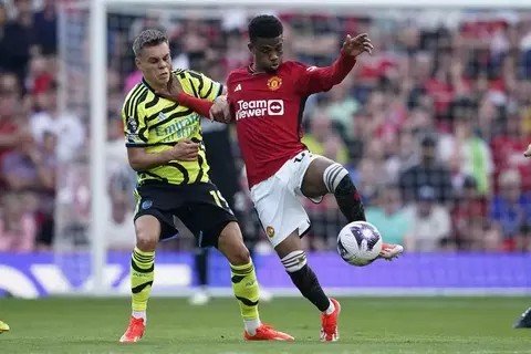 em>Pemain Arsenal Leandro Trossard (kiri) berebut bola dengan pemain Manchester United Amad Diallo pada pertandingan Liga Inggris di Stadion Old Trafford, Manchester, Minggu, 12 Mei 2024. (AP/Dave Thompson)