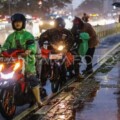 Ilustrasi - Sejumlah pengendara motor berhenti untuk memakai jas hujan (ANTARA FOTO/Idlan Dziqri Mahmudi)