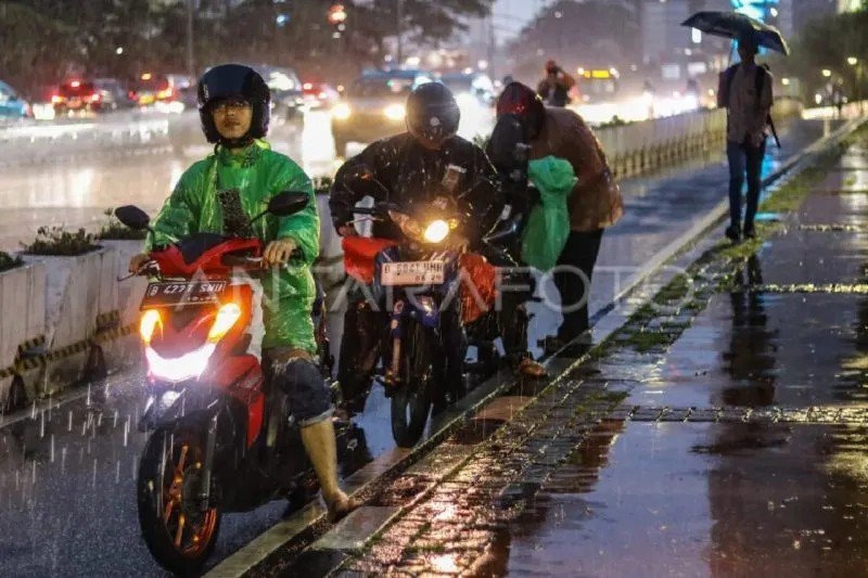 Ilustrasi - Sejumlah pengendara motor berhenti untuk memakai jas hujan (ANTARA FOTO/Idlan Dziqri Mahmudi)