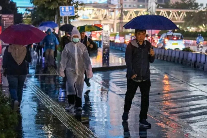 Sejumlah warga menggunakan payung saat turun hujan di kawasan Sudirman, Jakarta. (ANTARA FOTO/IDLAN DZIQRI MAHMUDI