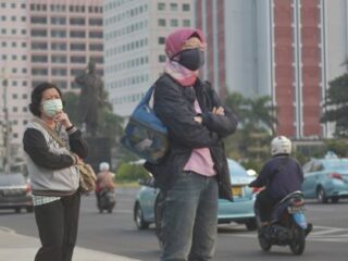 Ilustrasi warga menggunakan masker di Jakarta dengan kualitas udara tidak sehat saat indeks polusi meningkat. (Courtesy: Getty Images)