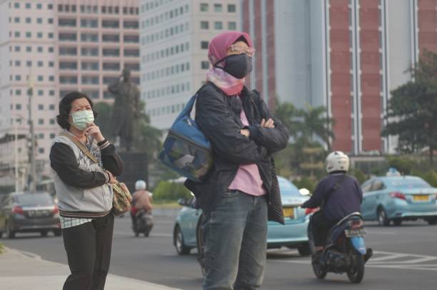 Ilustrasi warga menggunakan masker di Jakarta dengan kualitas udara tidak sehat saat indeks polusi meningkat. (Courtesy: Getty Images)