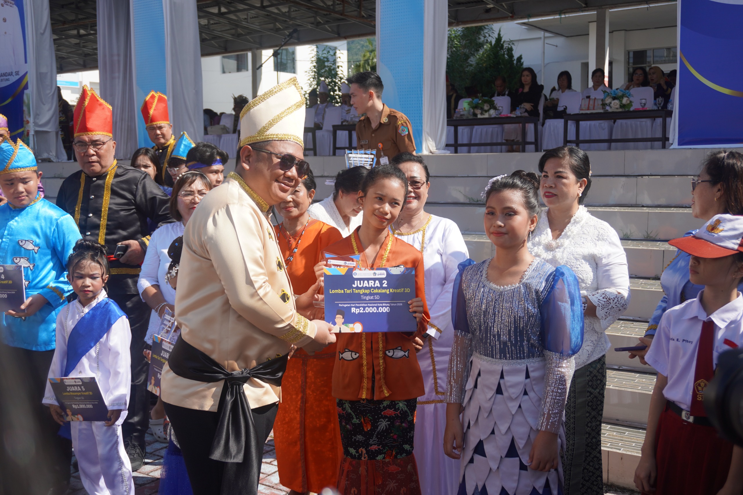 Wakil wali kota Bitung Randito Maringka menyerahkan hadiah lomba dalam rangka hardiknas 2026.