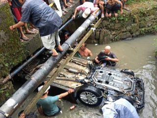 Dihantam hujan deras, mobil Ertiga di Bengkong hanyut dan terbalik di parit!